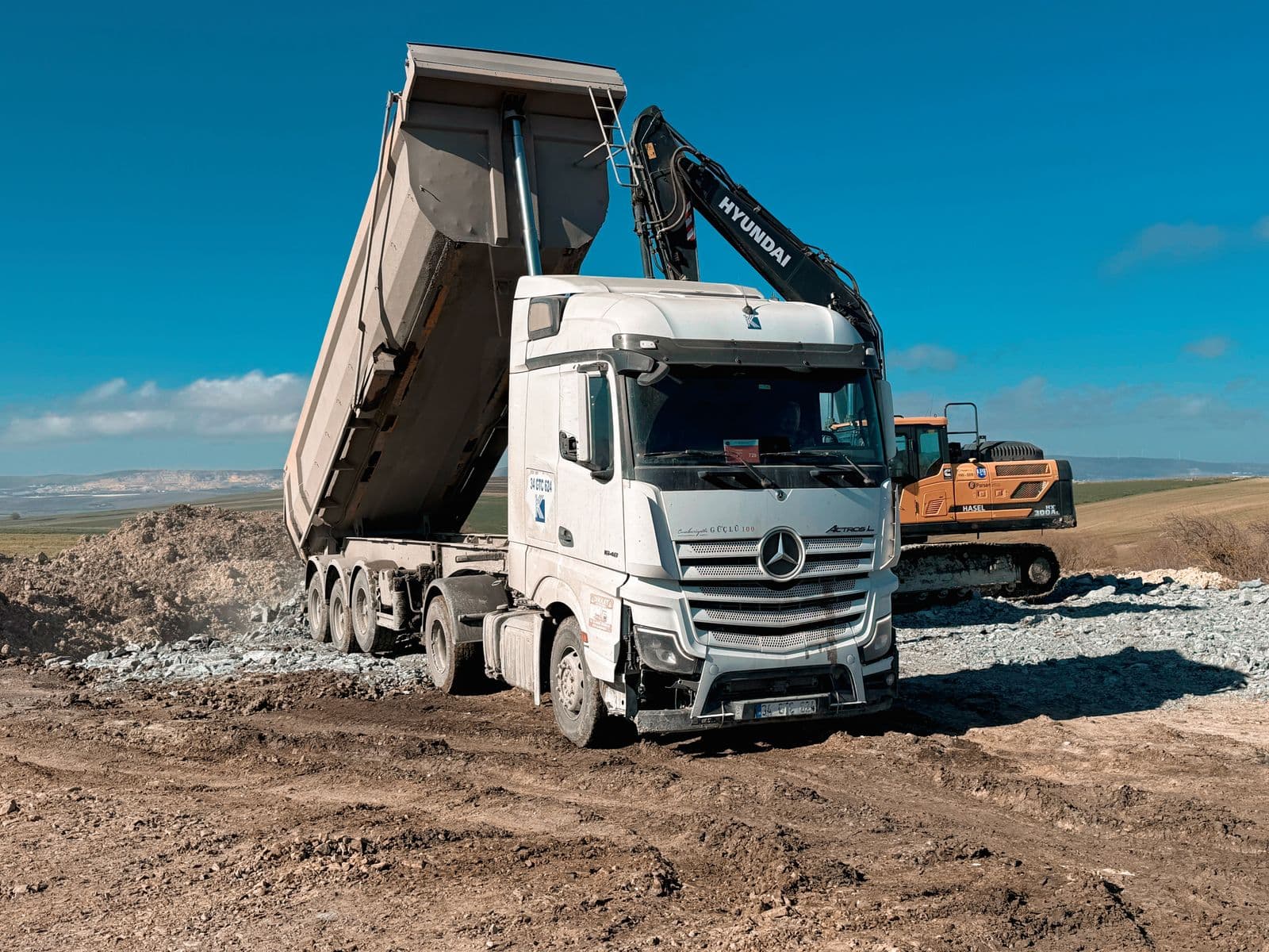 Volquete de obra cargando áridos en una construcción